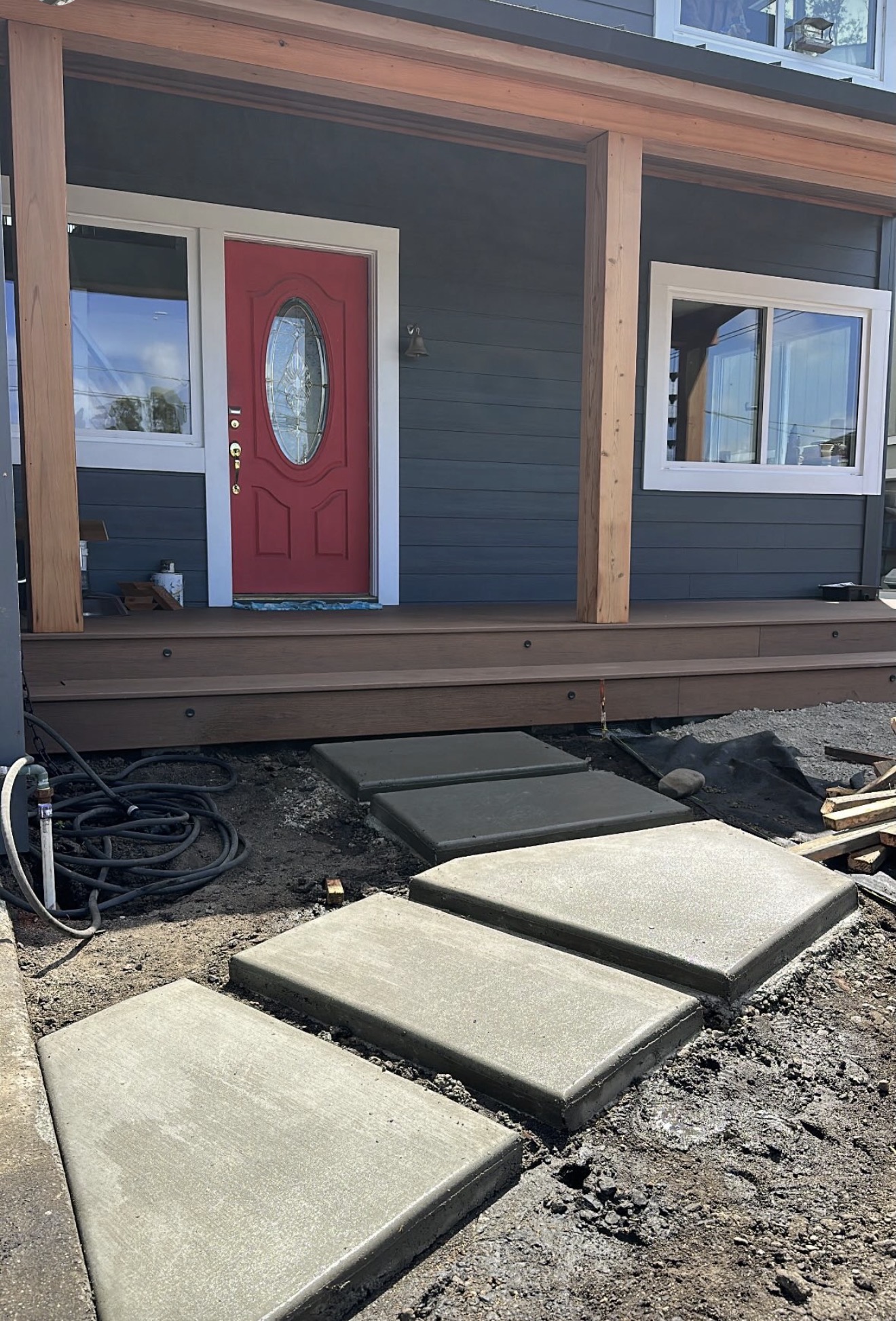 CHR concrete stepping pads with a broom finish leading to a wooden porch