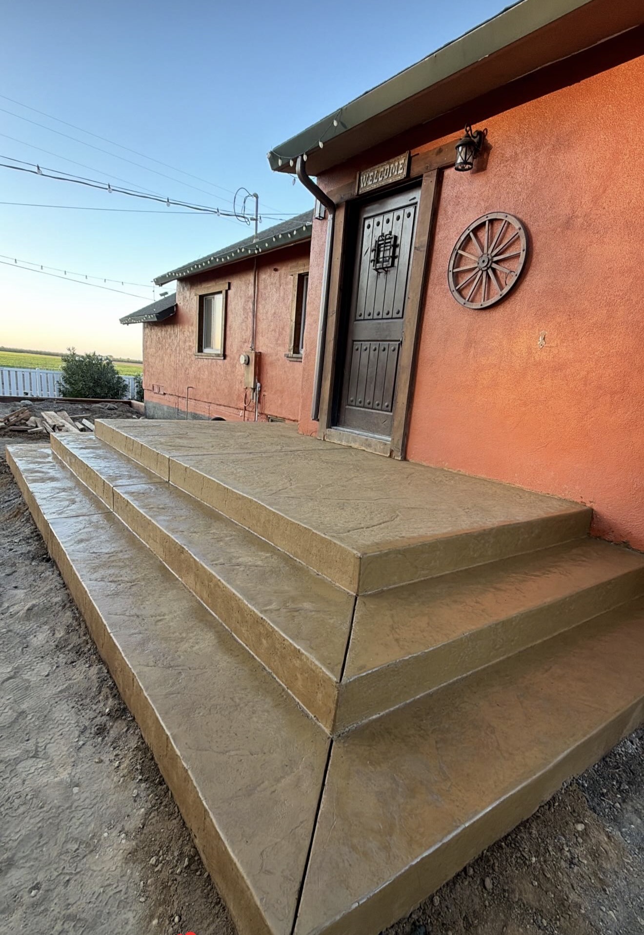 CHR stamped concrete steps and entry landing beside a red exterior wall